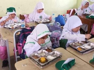Siswa sedang menyantap Makanan Bergizi Gratis (MBG).