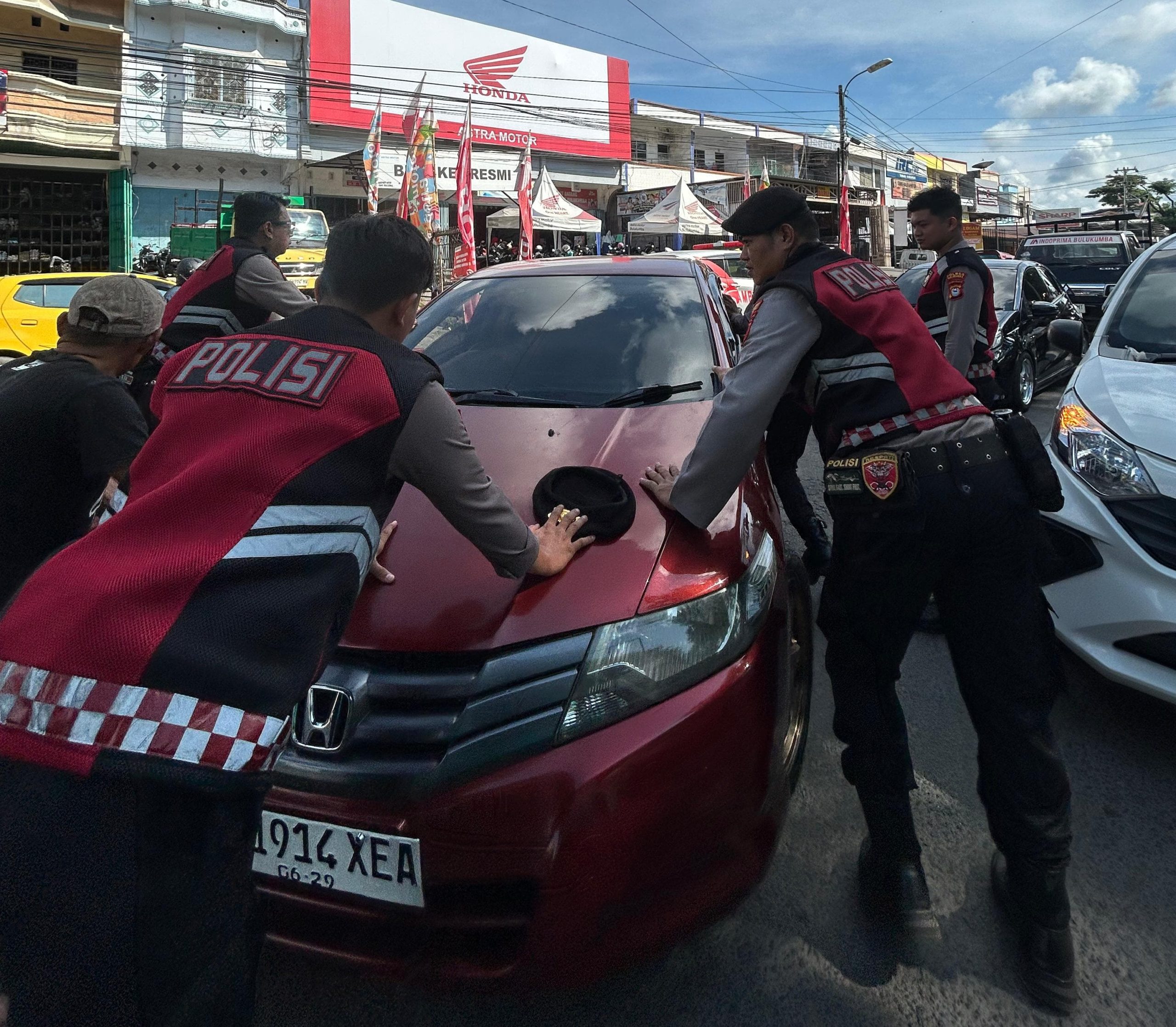 Petugas Unit Patroli Presisi Sat Samapta Polres Bulukumba mengevakuasi mobil mogok di jalur dua depan Pasar Sentral Bulukumba
