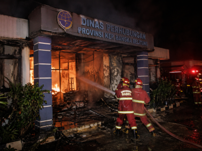Petugas pemadam kebakaran berupaya memadamkan api yang membakar kantor Dinas Perhubungan Provinsi Kepulauan Bangka Belitung pada malam hari.